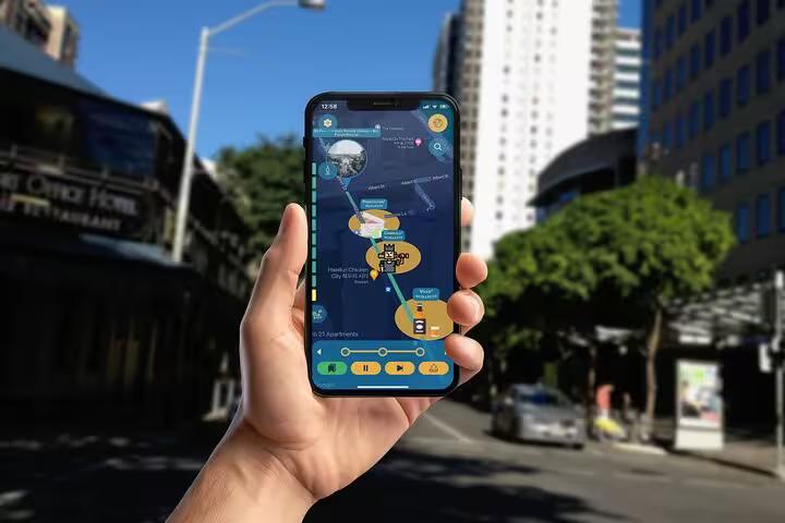 Hand holding smartphone displaying Brisbane dark history self-guided walking tour app map on city street
